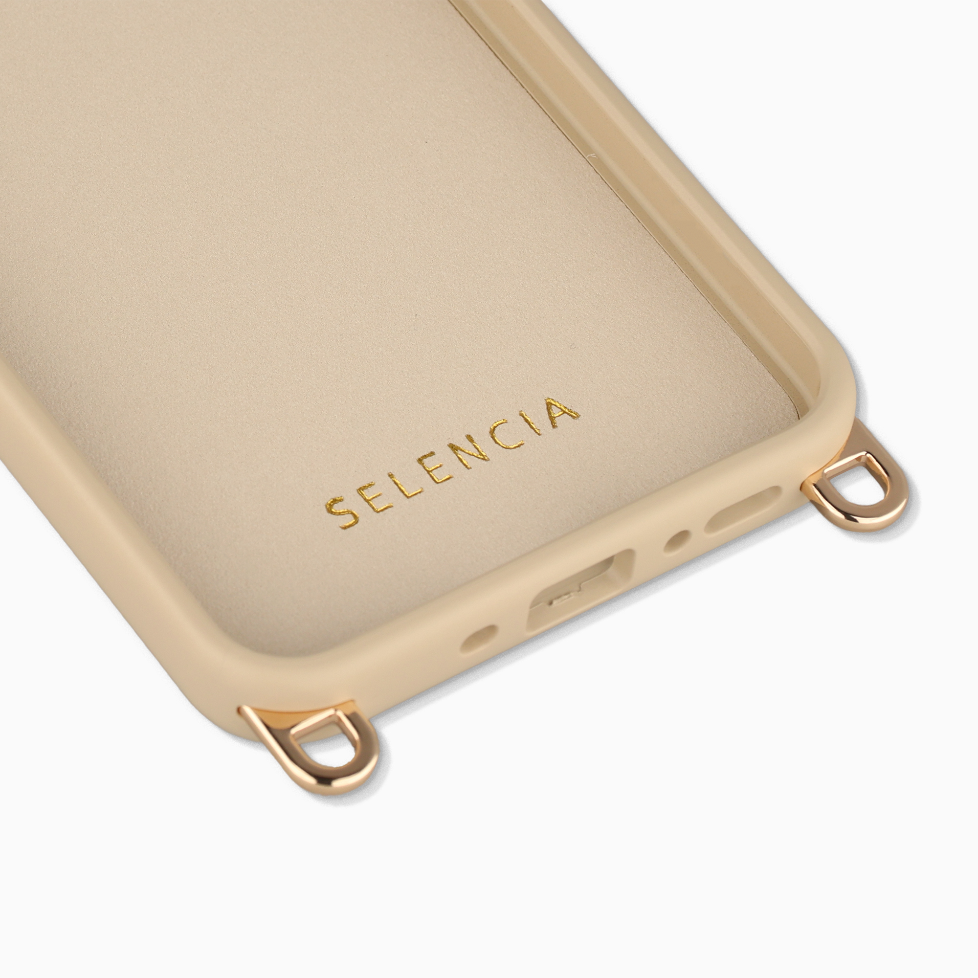 Een licht beige telefoonhoesje met gouden lussen en letters.