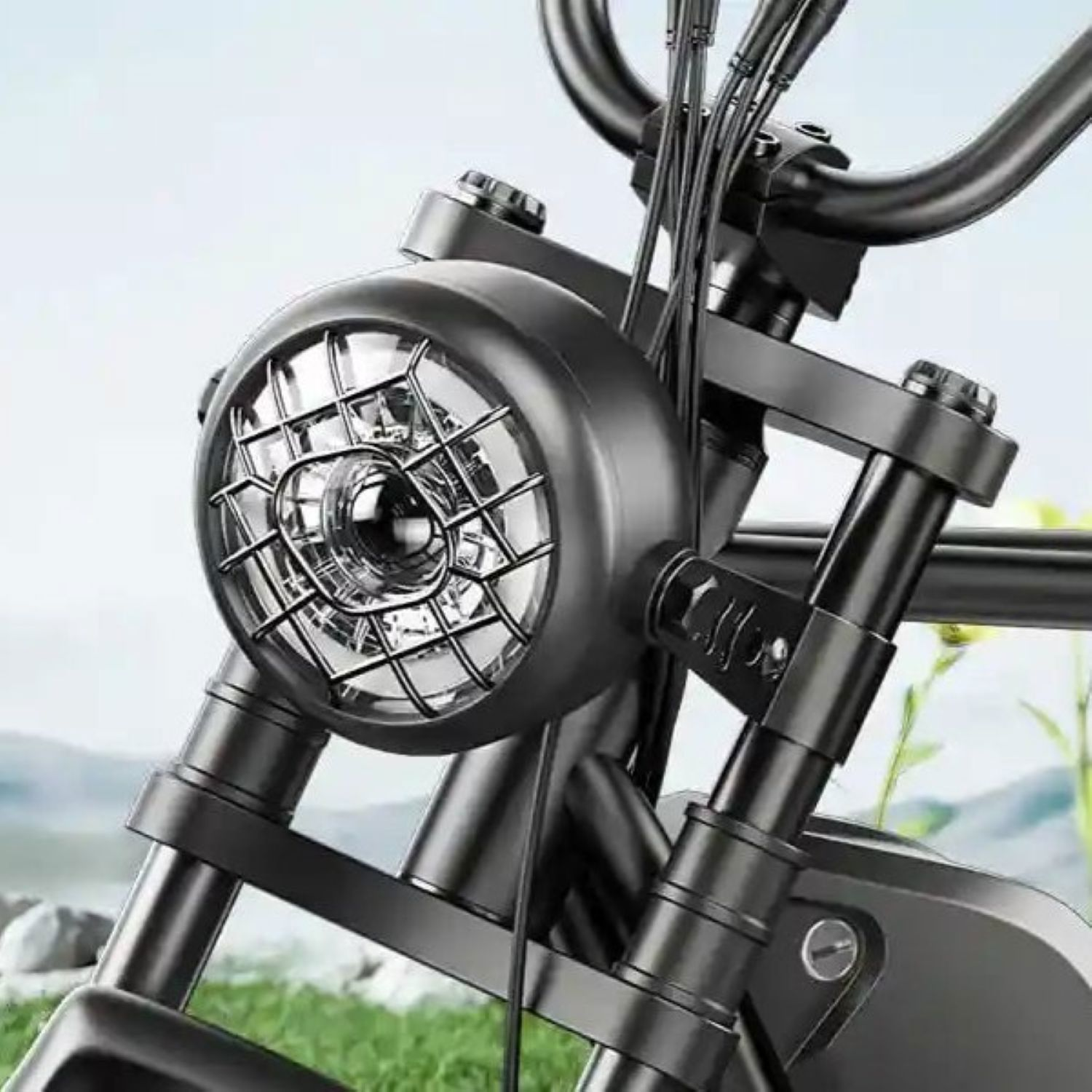 Un faro de motocicleta negro con rejilla metálica frente a un paisaje.