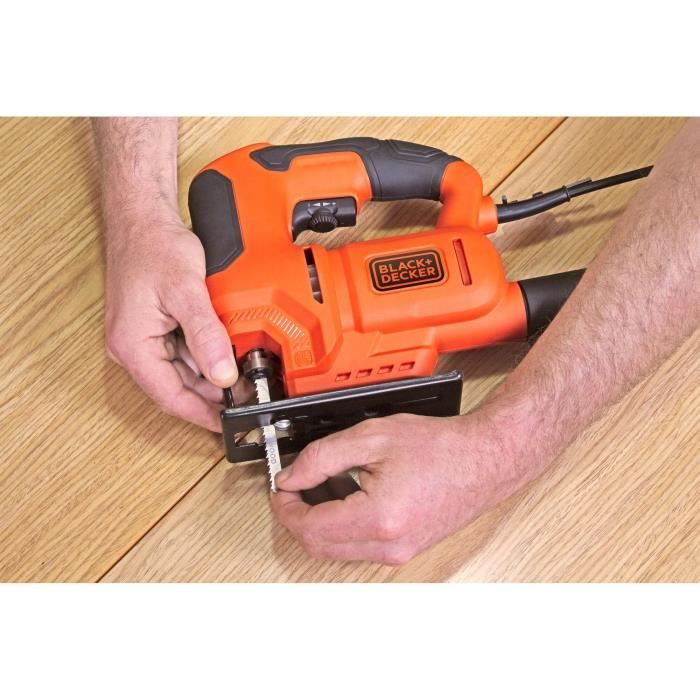 Pialla da traforo arancione Black+Decker su superficie in legno, tenuta in mano.