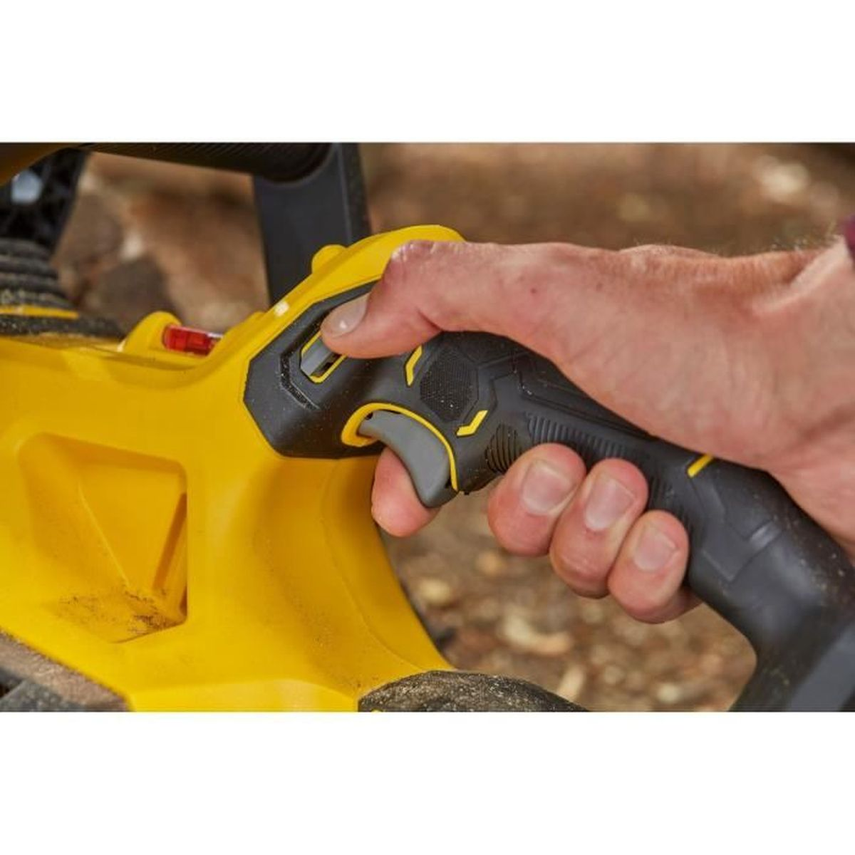 Una mano impugna un manico giallo per attrezzi con accenti neri e grigi.
