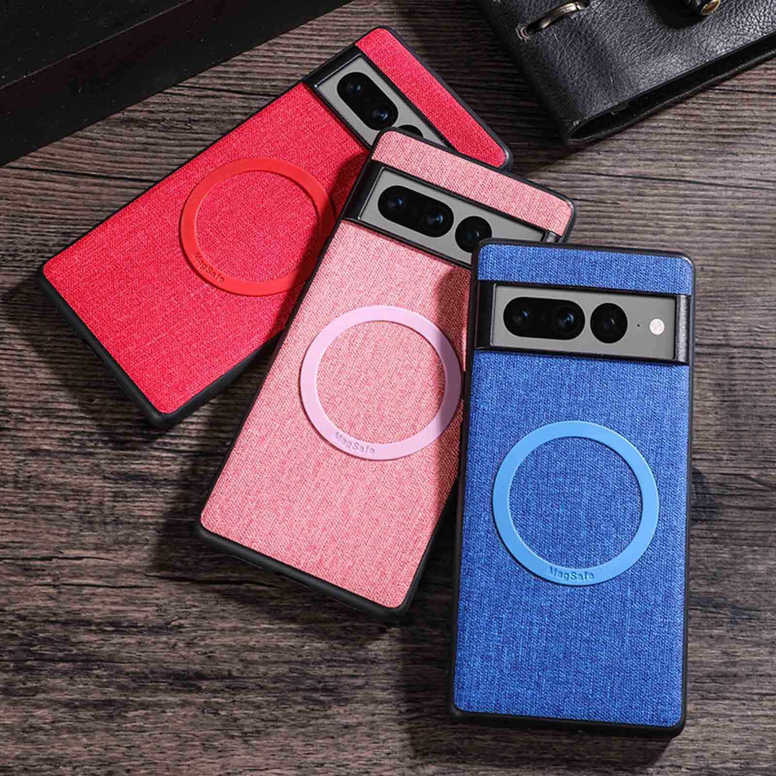 Drei Handyhüllen in Rot, Rosa und Blau mit MagSafe-Ringen liegen auf Holz.