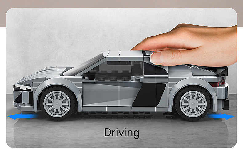 Graues Lego-Auto, von Hand gehalten, mit blauen Pfeilen, die Vorwärtsbewegung anzeigen.
