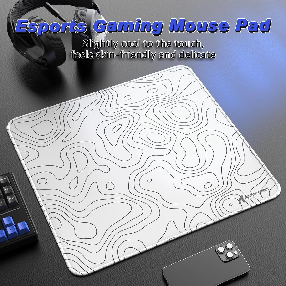 White gaming mousepad with black topographic pattern, headphones, keyboard and phone.