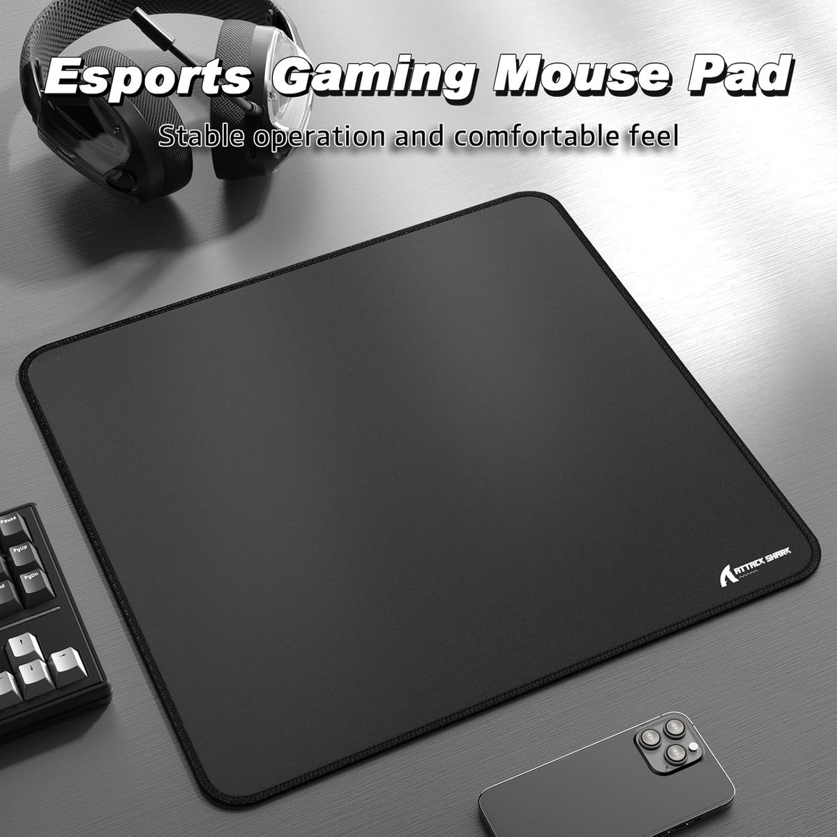 Black esports gaming mouse pad with headphones, keyboard, and phone.