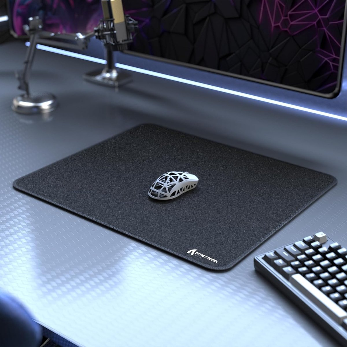 Black mousepad with white skeletal mouse and keyboard on a desk.