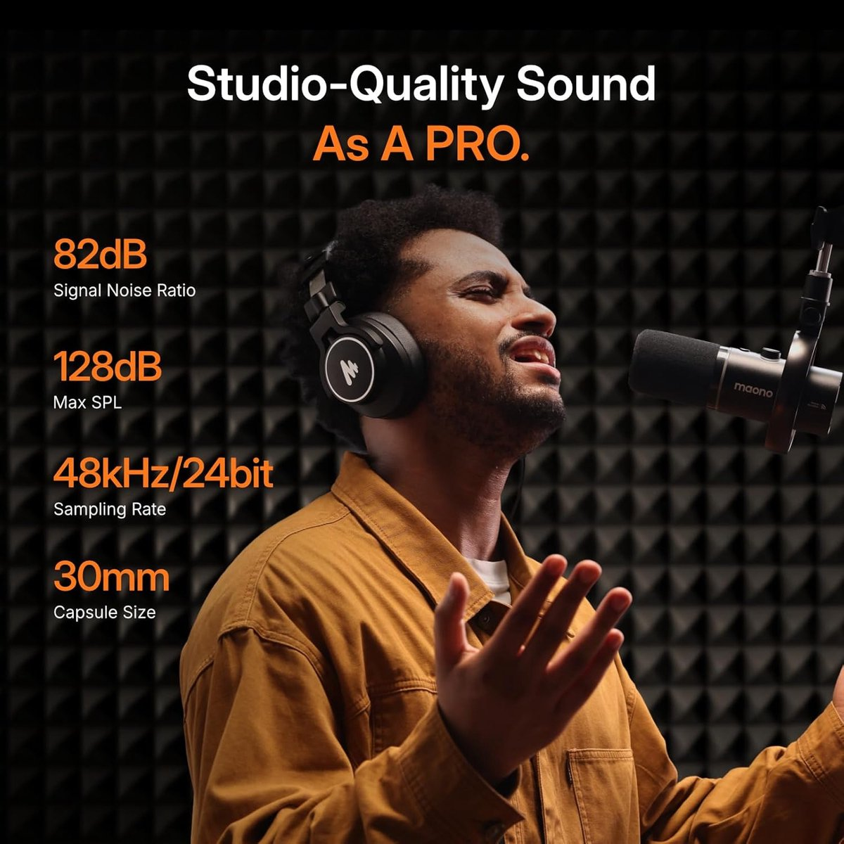 Man wearing headphones sings into a microphone, studio acoustics in background.