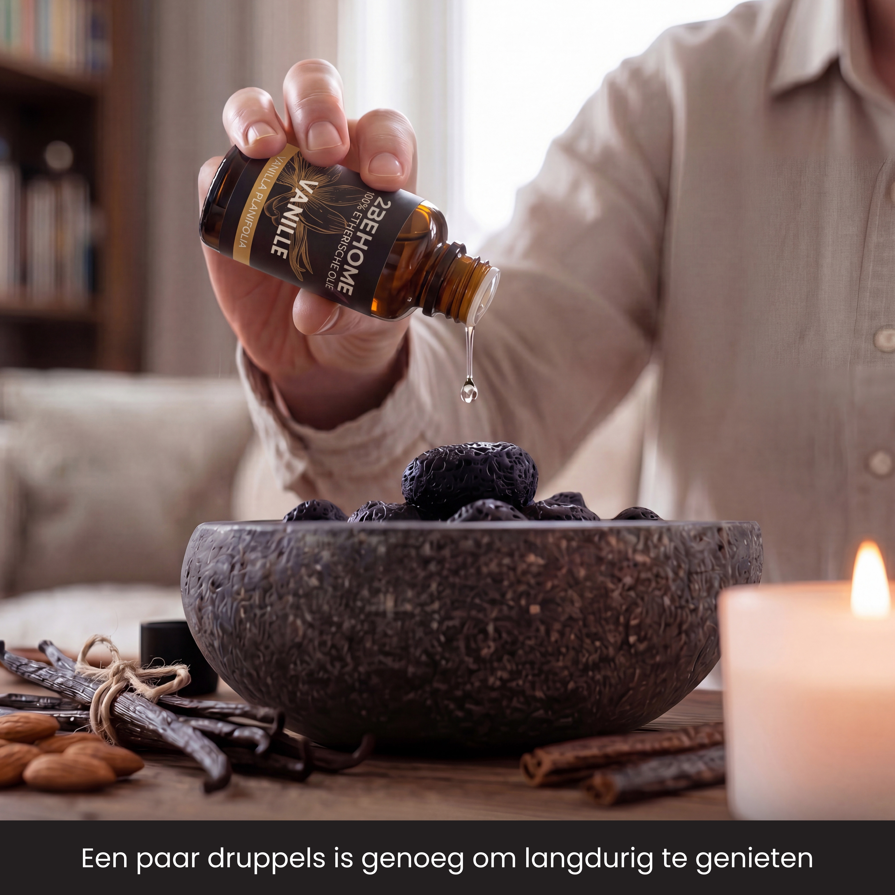 A hand drips vanilla oil into a bowl with dark spheres. Almonds and vanilla pods lie beside it.