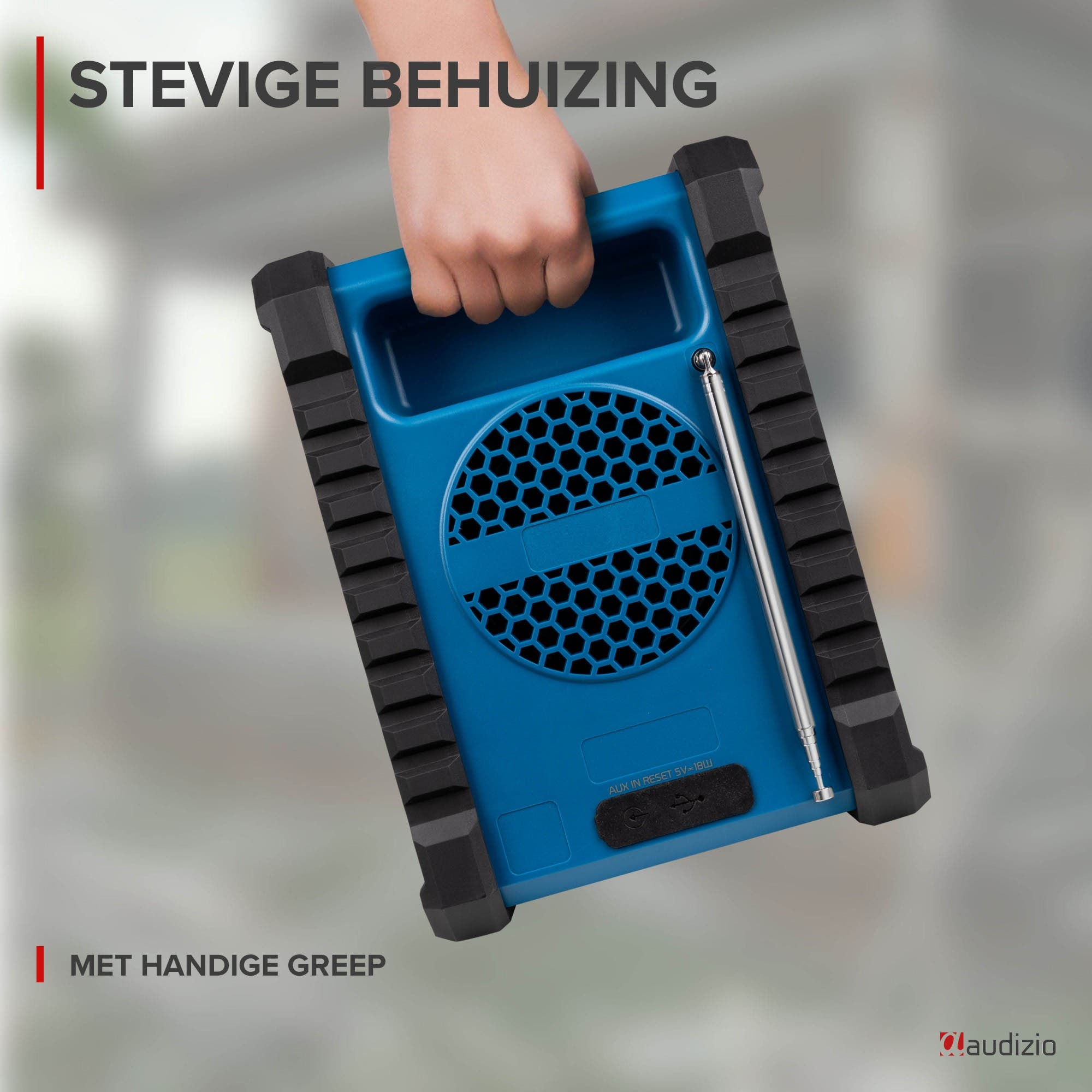 Una mano sostiene una radio azul con parachoques de goma negros y una antena extensible.