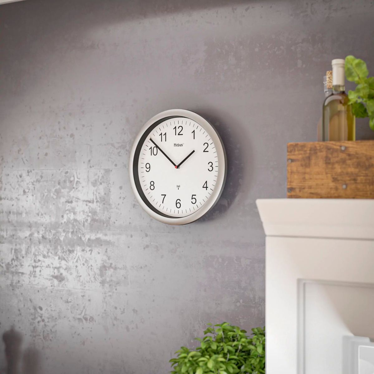 Un orologio da parete bianco con lancette nere è appeso a un muro grigio.