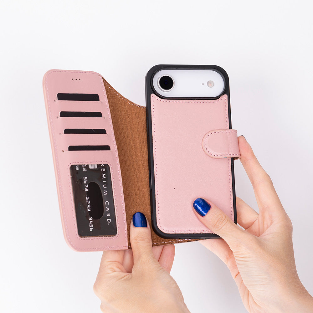 Bir el, kart yuvaları ve kredi kartı olan pembe bir telefon kılıfı tutuyor.