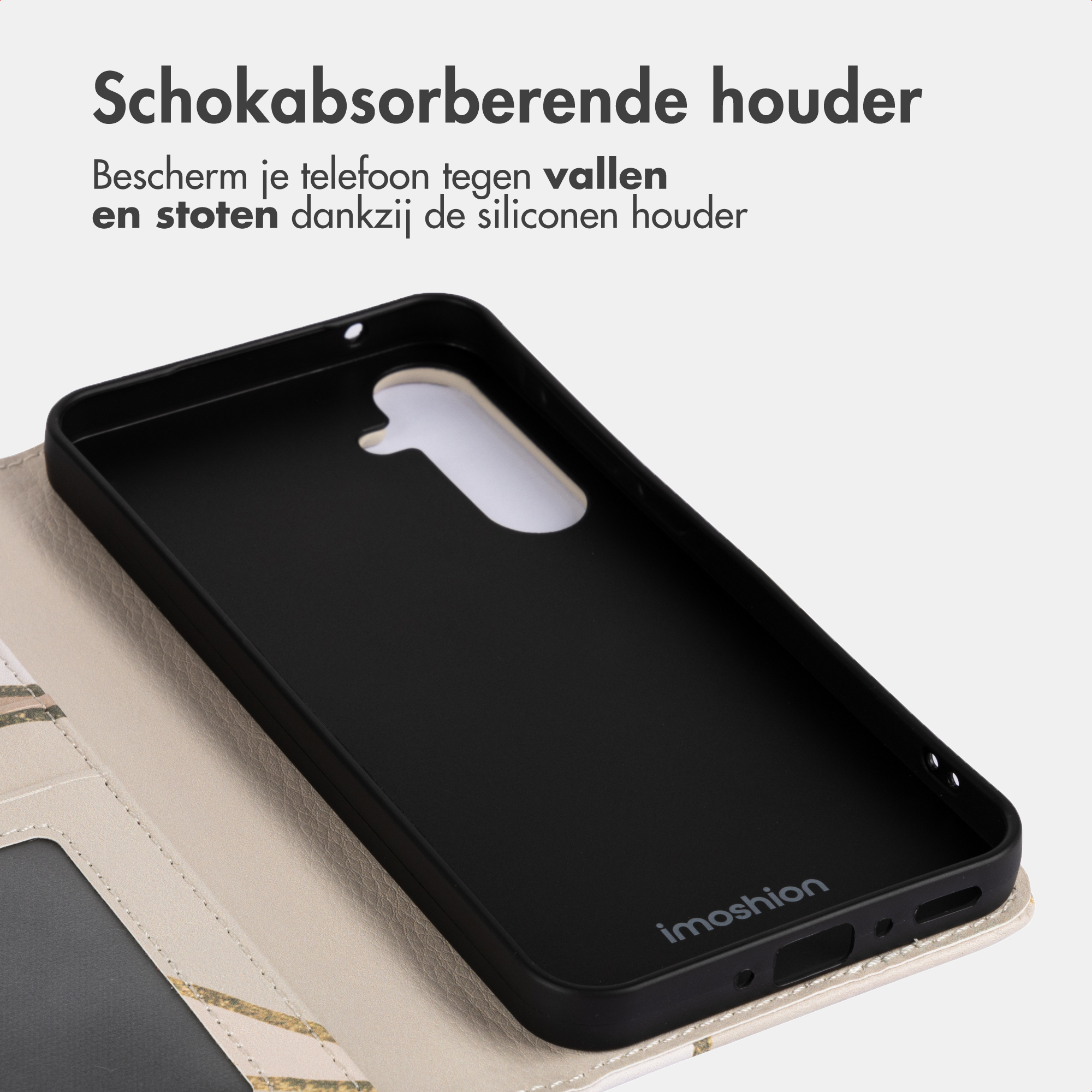 Custodia in silicone nero per telefono, aperta e appoggiata su una custodia chiara.