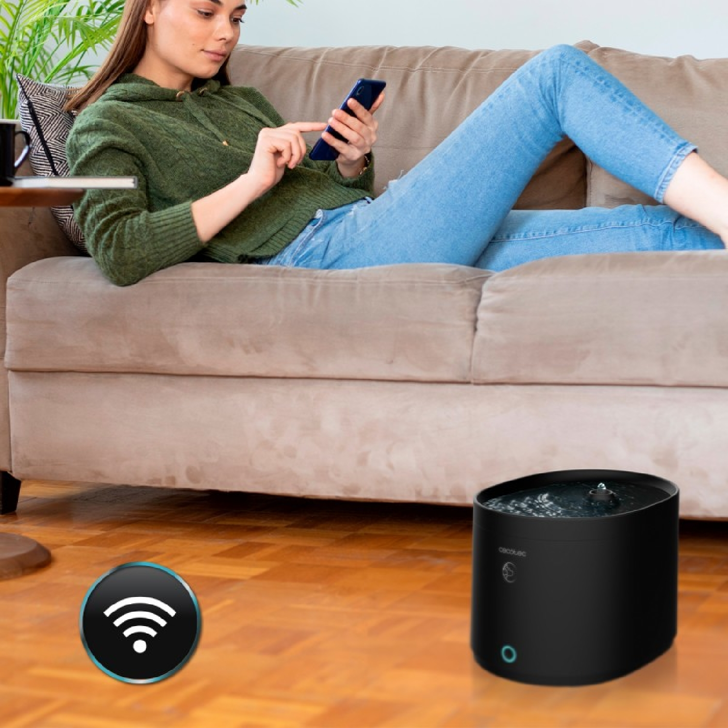 Mujer en sofá con teléfono, junto a dispensador de agua y icono Wi-Fi.