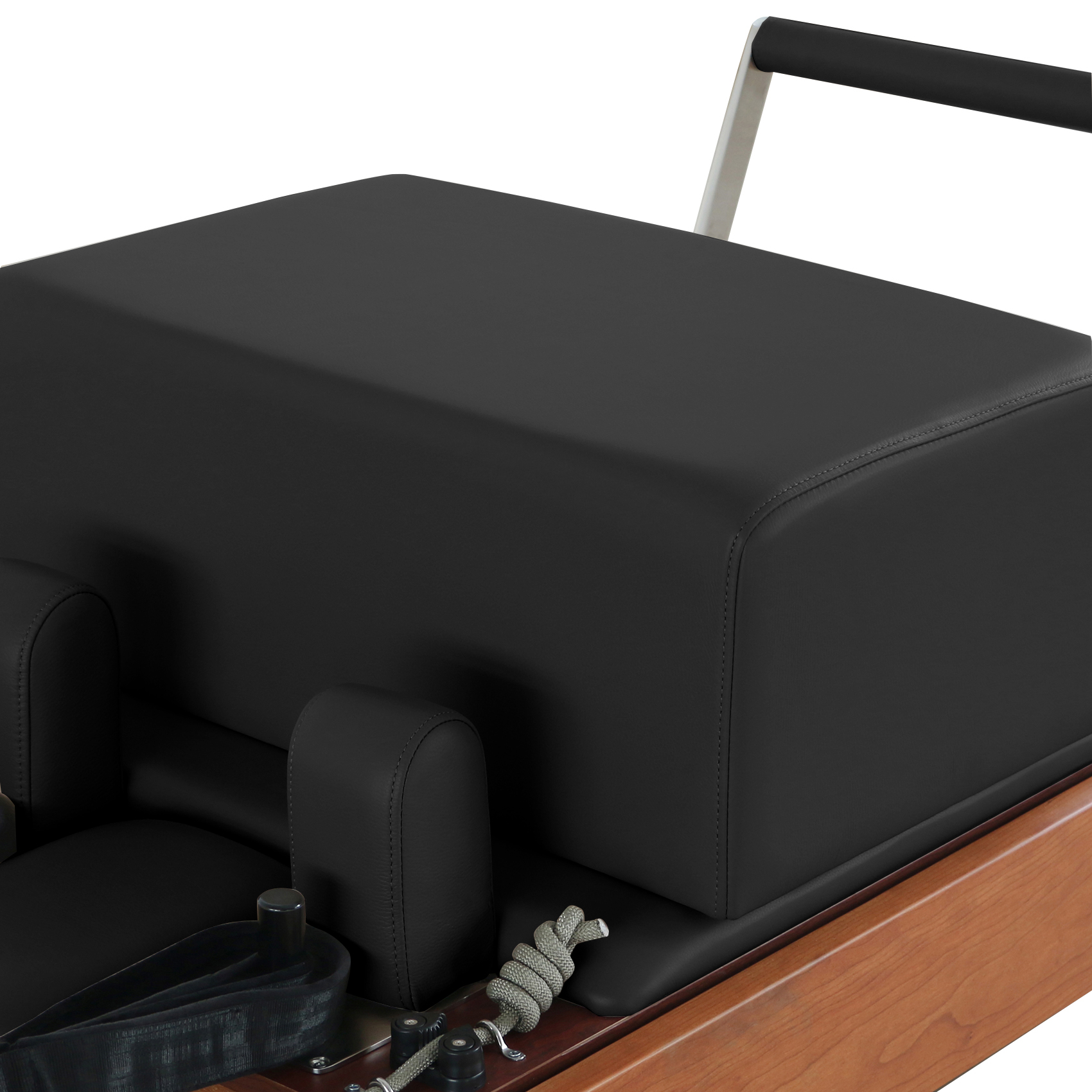 Un reformer de Pilates negro con base de madera, asas y correas.