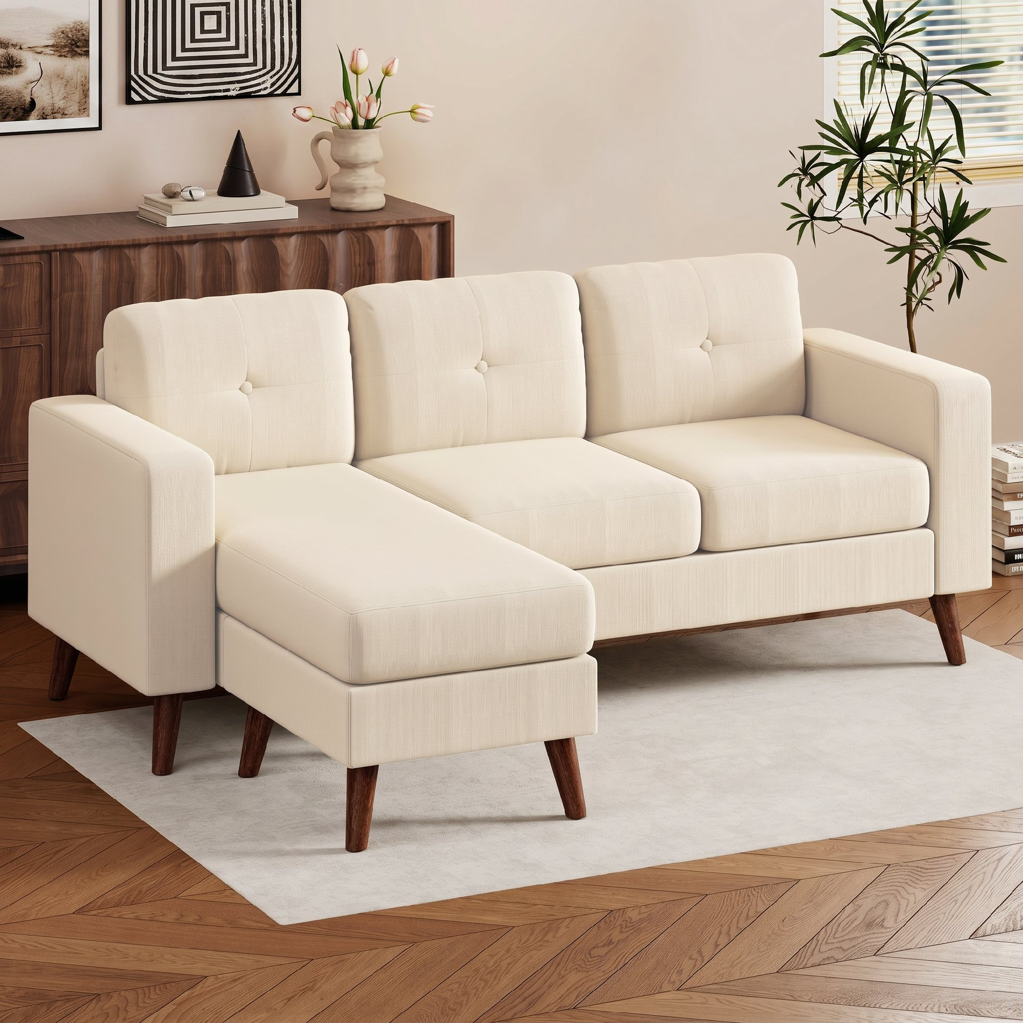 Un sofá seccional crema con cojines capitoné sobre una alfombra clara. Muebles de madera y planta.