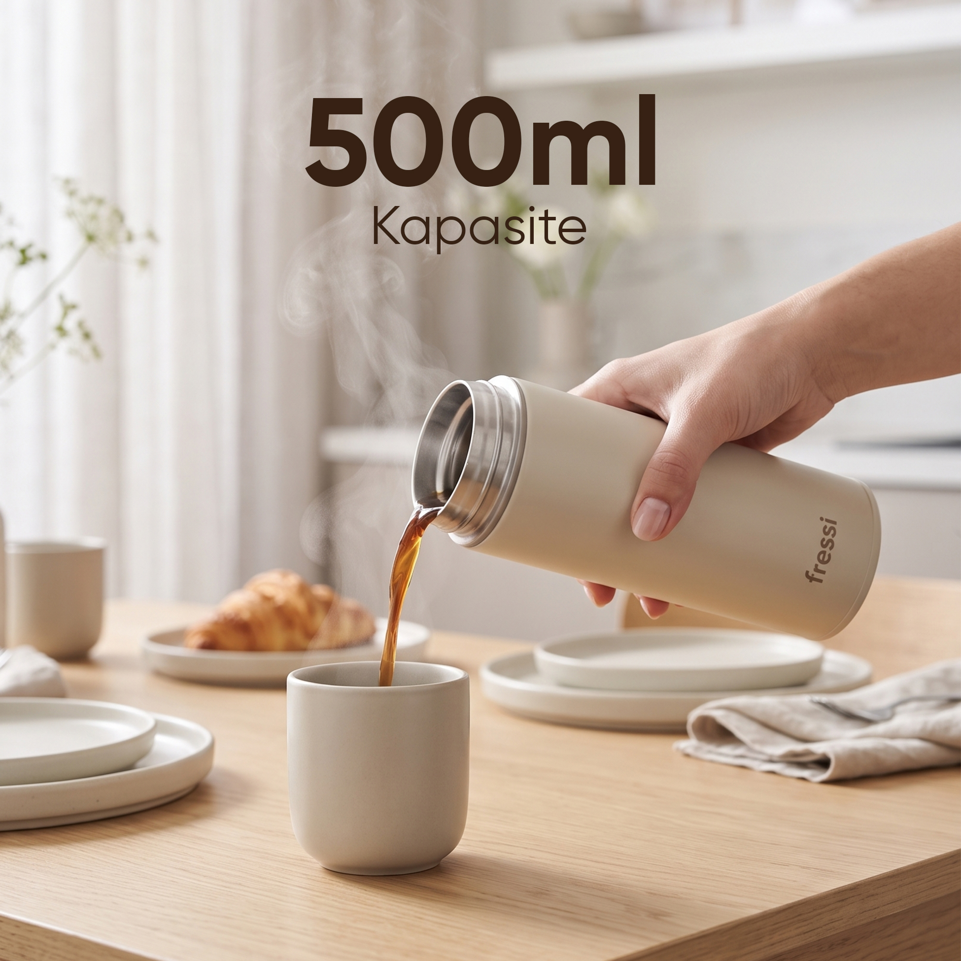 Bir el, şişeden fincana kahve döküyor. Yakında bir kruvasan var.