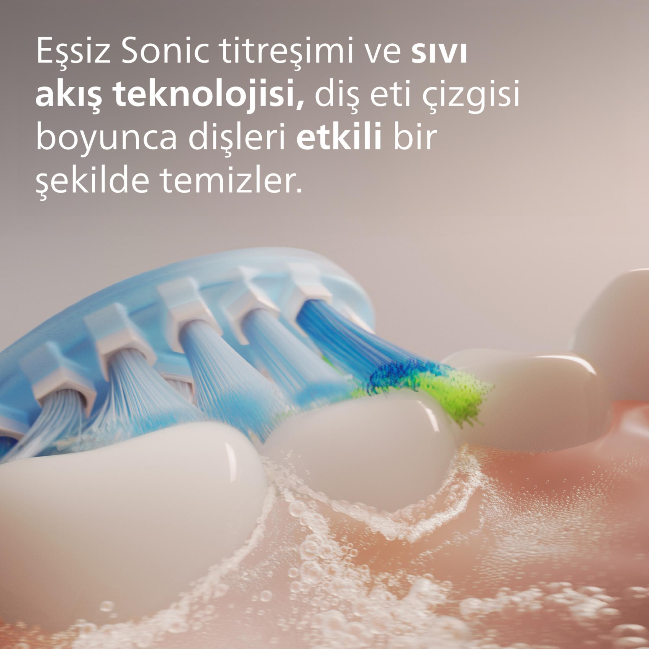 Spazzolino elettrico con setole blu/verdi che pulisce i denti, con schiuma.