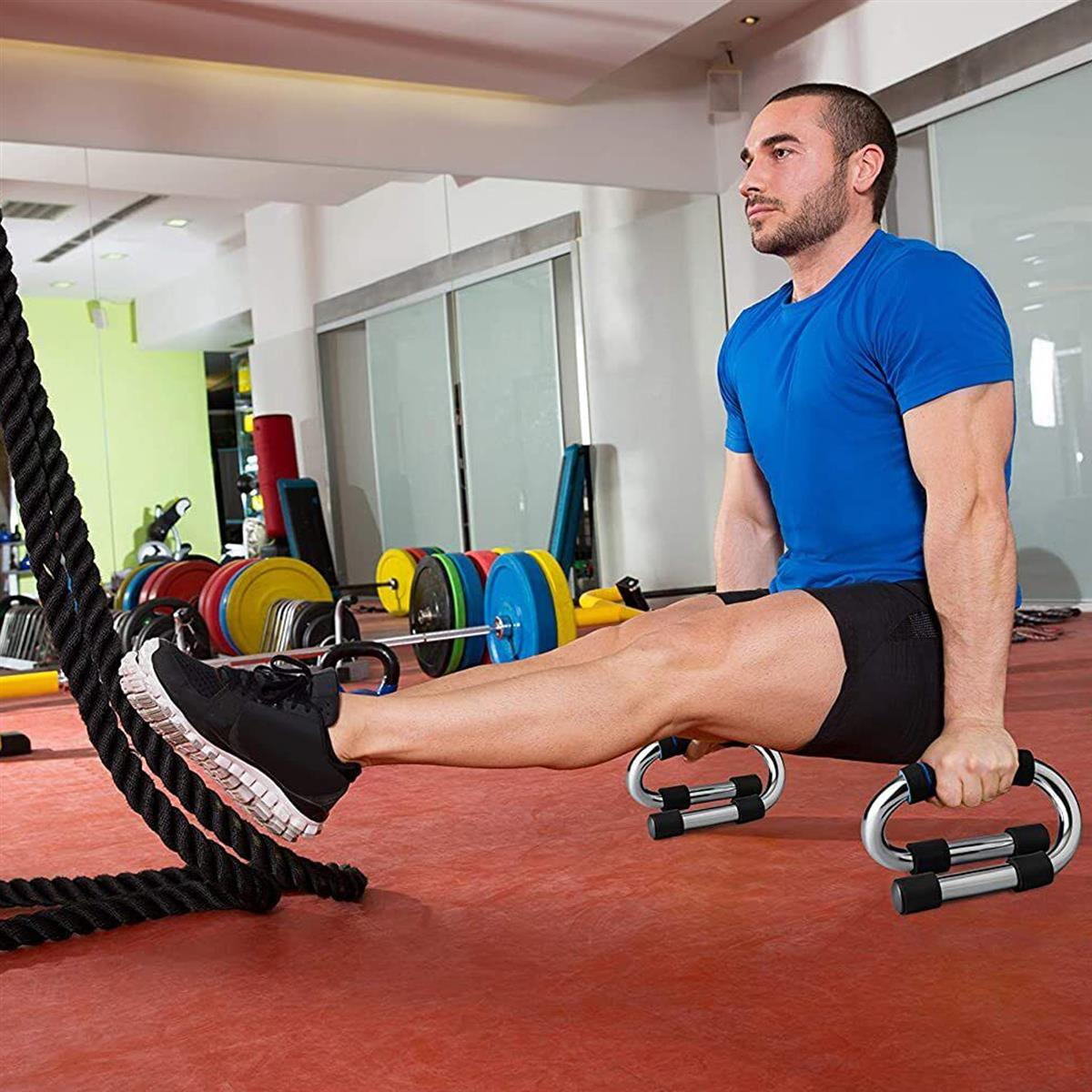 Ein Mann macht Liegestütze im Fitnessstudio auf einem roten Boden.
