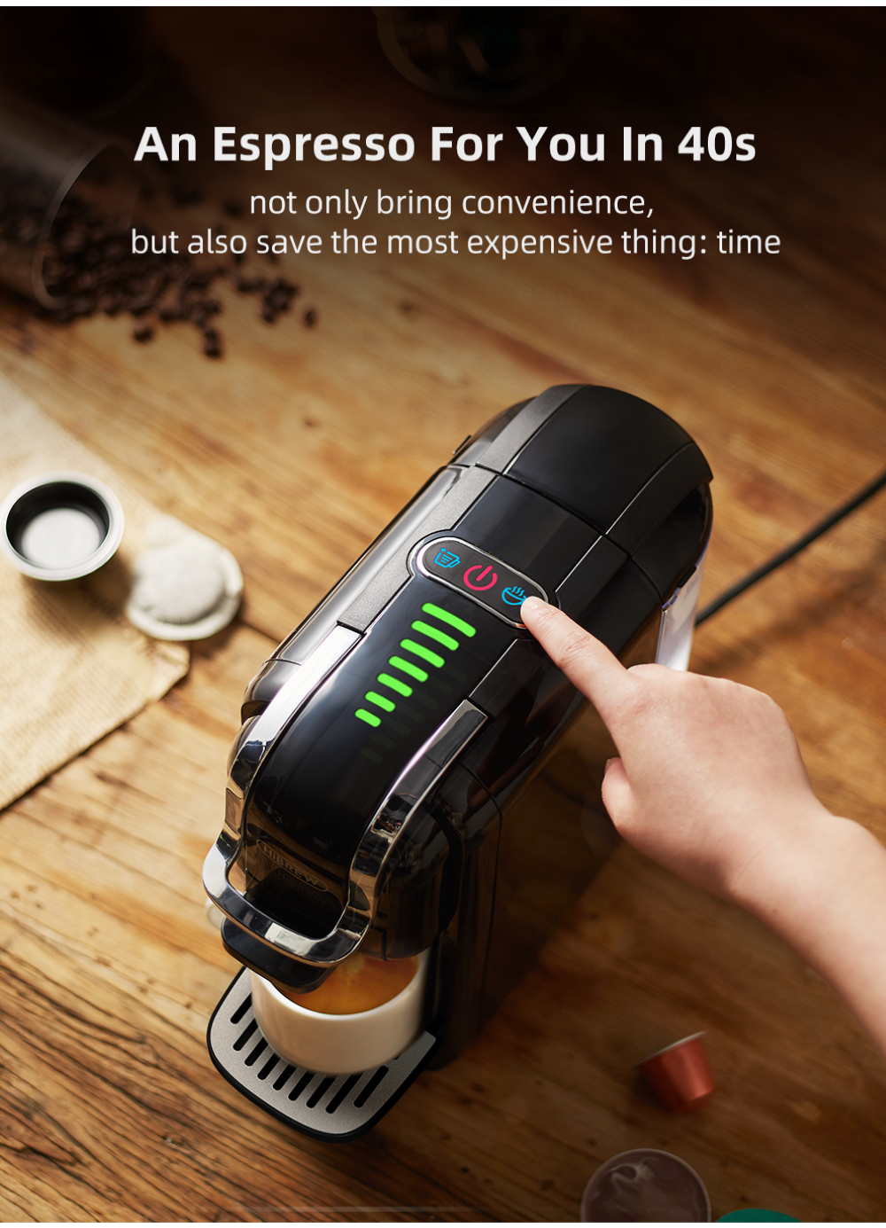 Una mano preme una macchina da caffè nera con spie luminose verdi.
