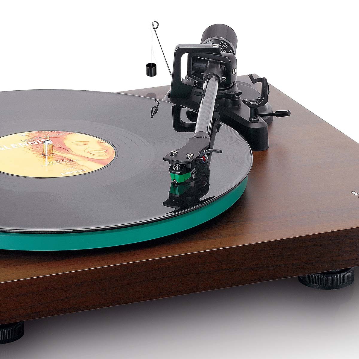 Gramofon z zieloną matą, czarnym winylem i ramieniem. Mały ciężarek zwisa u góry.
