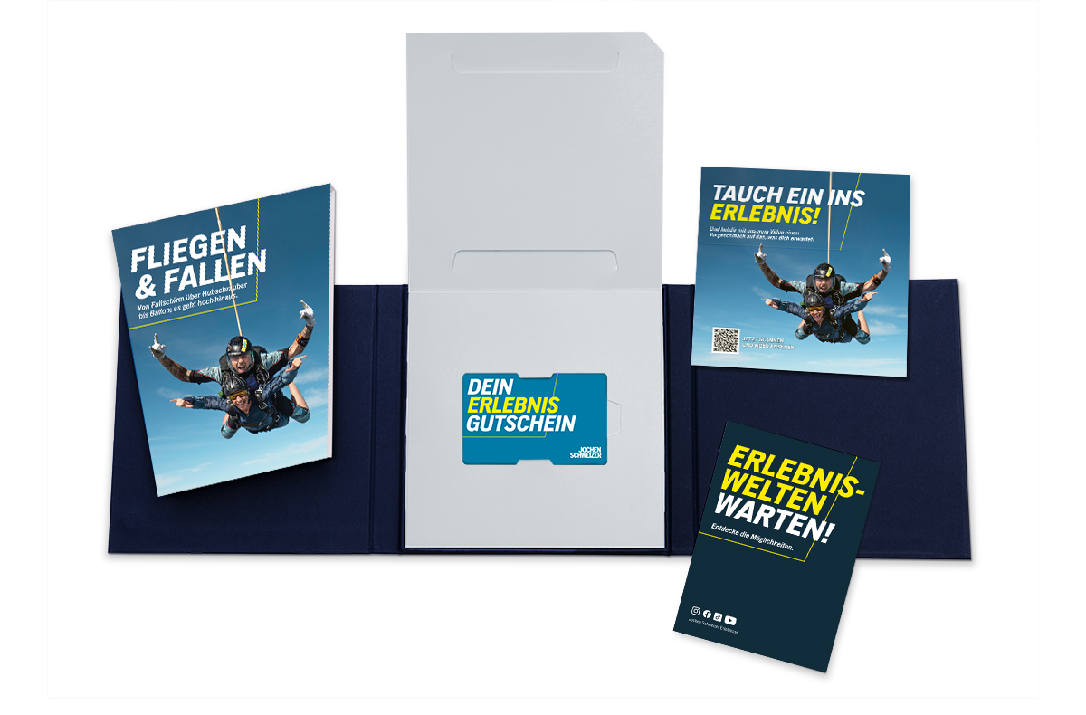 Ein dunkelblauer Ordner öffnet sich und zeigt ein Erlebnis-Gutschein-Set.