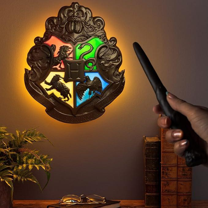 Herb Hogwartu świeci, ręka trzyma różdżkę.