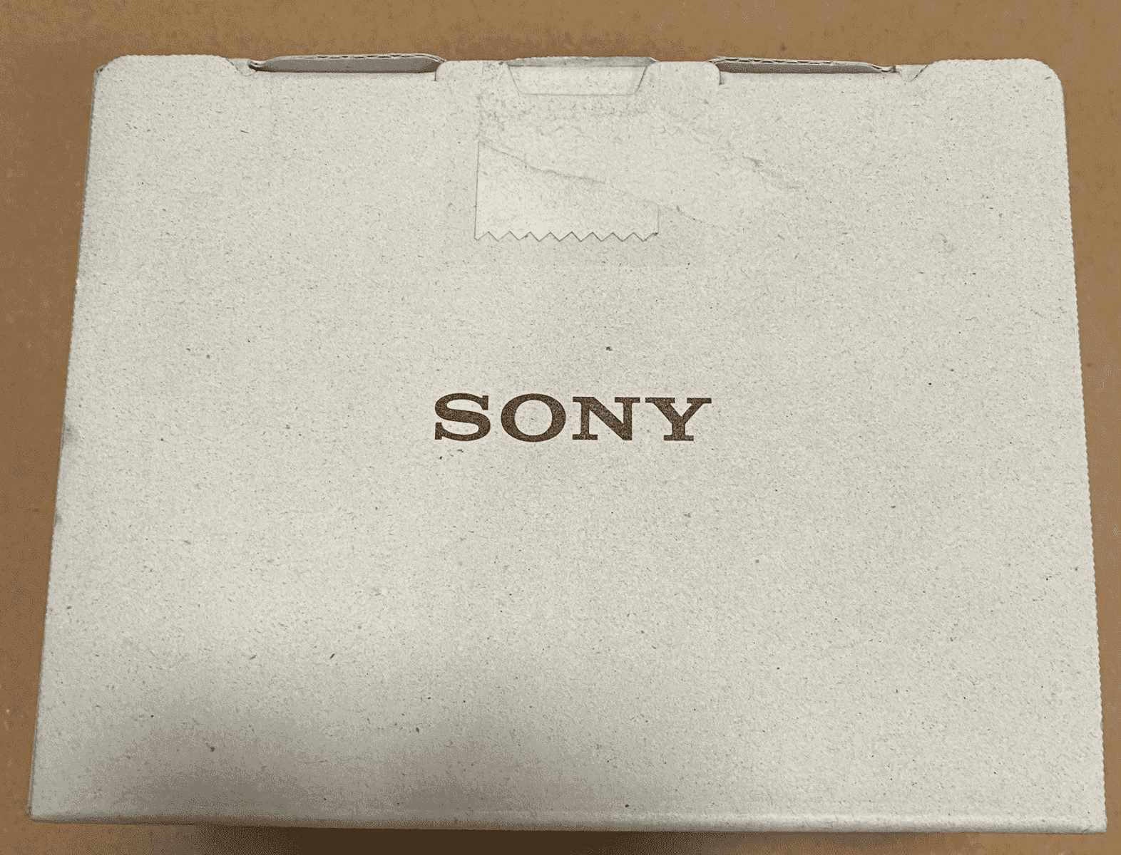 Caja blanca de Sony con un sello en zigzag en la parte superior.