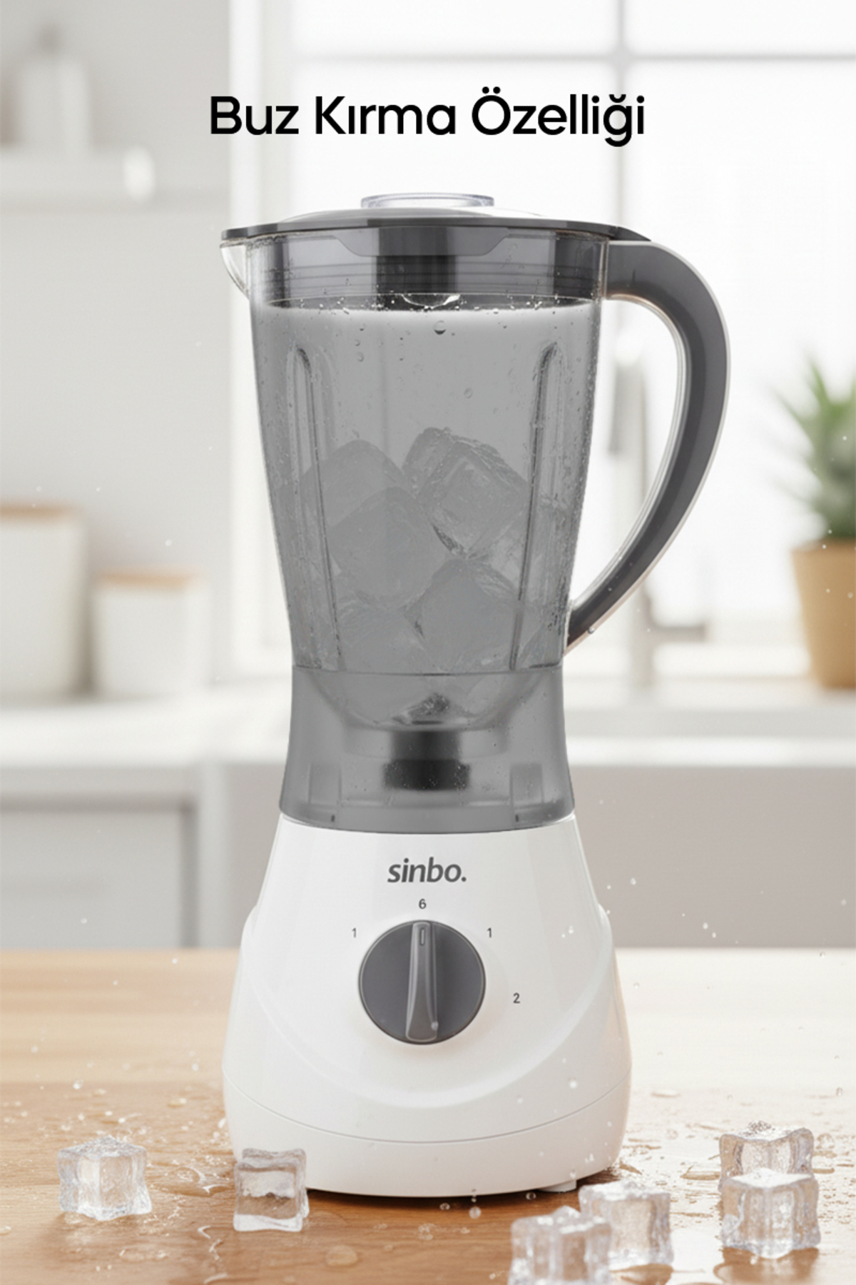 Ahşap masa üzerinde ve sürahide buz küpleri olan beyaz blender.