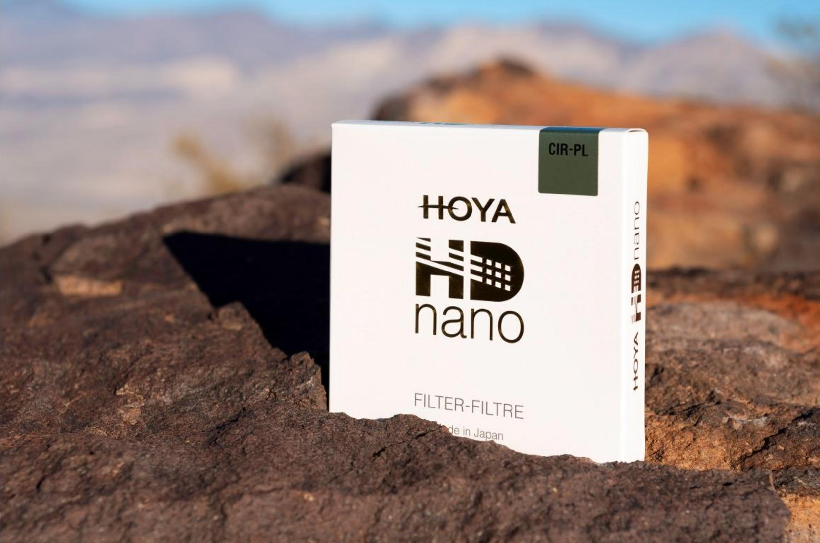 Eine weiße HOYA HD nano Filter-Box steht auf Felsen im Freien.