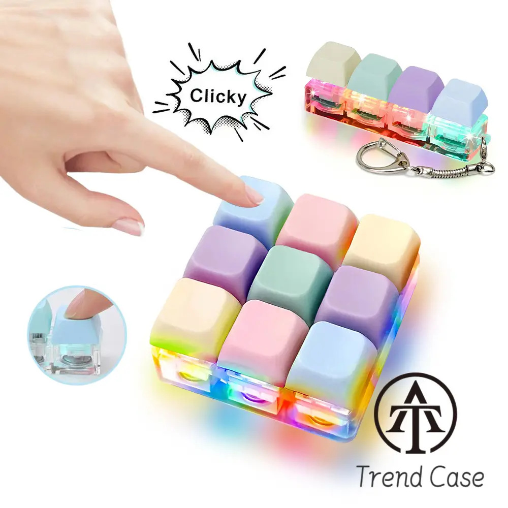 Ein Finger drückt auf bunte Tastenkappen über leuchtenden LEDs. Eine Schlüsselkette mit drei Tastenkappen.