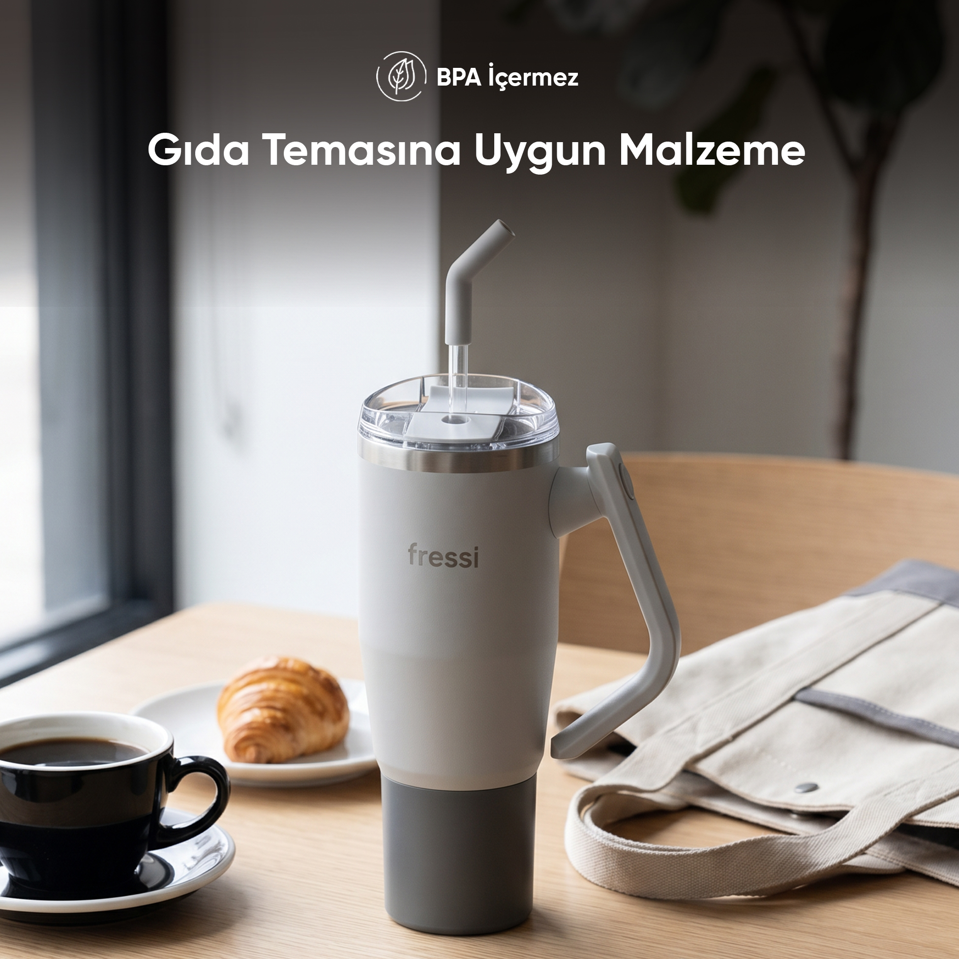Gri renkli pipetli bardak, kahve ve kruvasan ahşap masada.