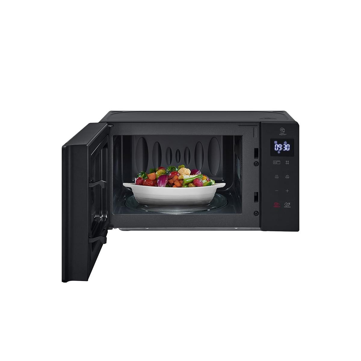Un microondas combinado negro con la puerta abierta, mostrando un bol de verduras dentro.