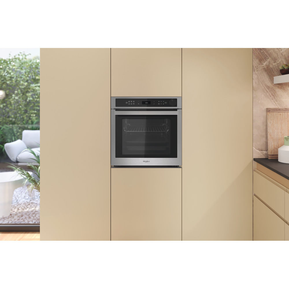 Forno da incasso moderno in cucina beige chiaro, con area giardino a sinistra.