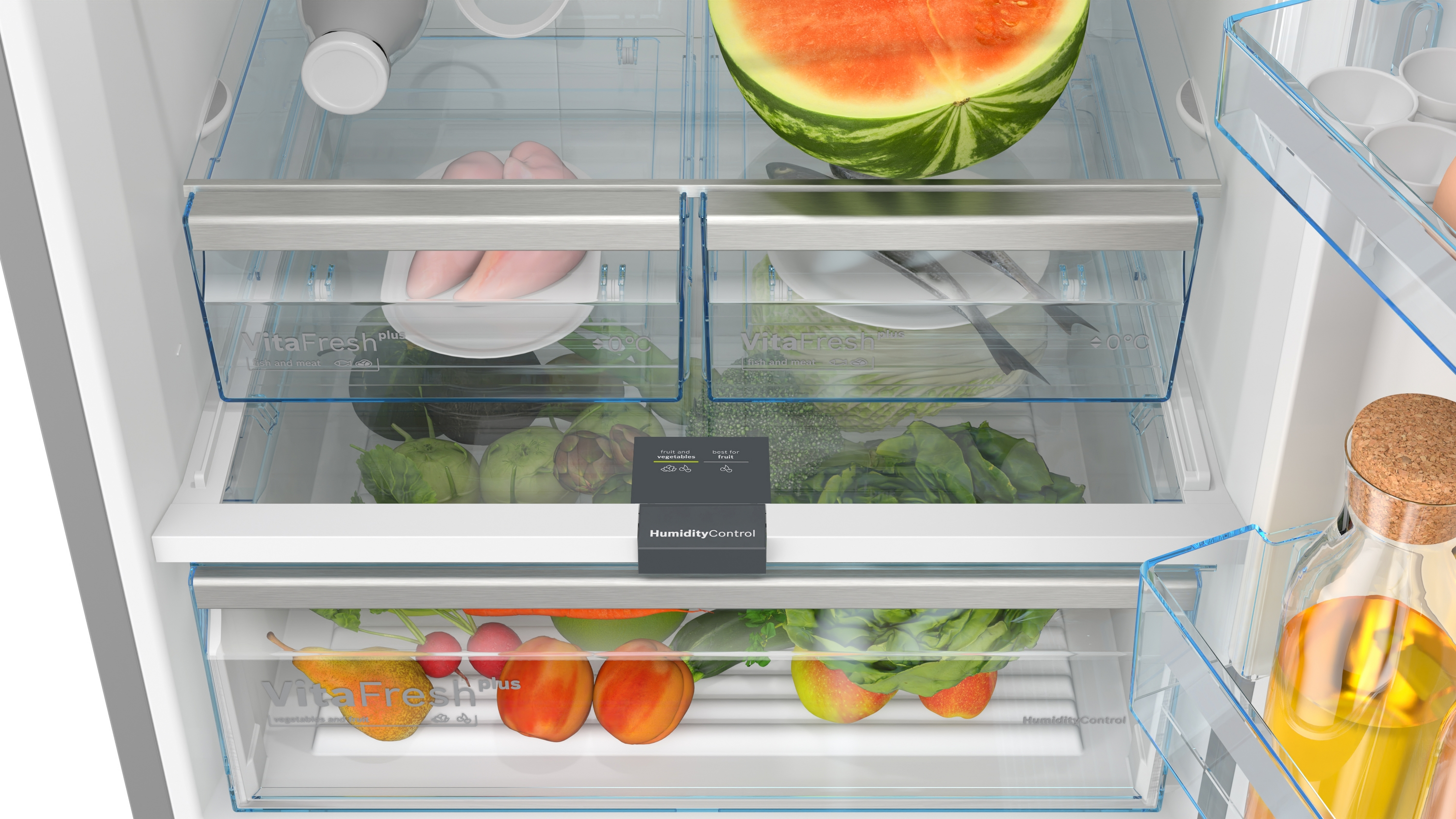 Ein Kühlschrank mit Obst und Gemüse in Schubladen. Wassermelone oben.