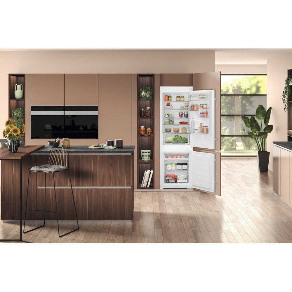 Un frigorifero-congelatore aperto in una cucina moderna con pavimenti in legno.