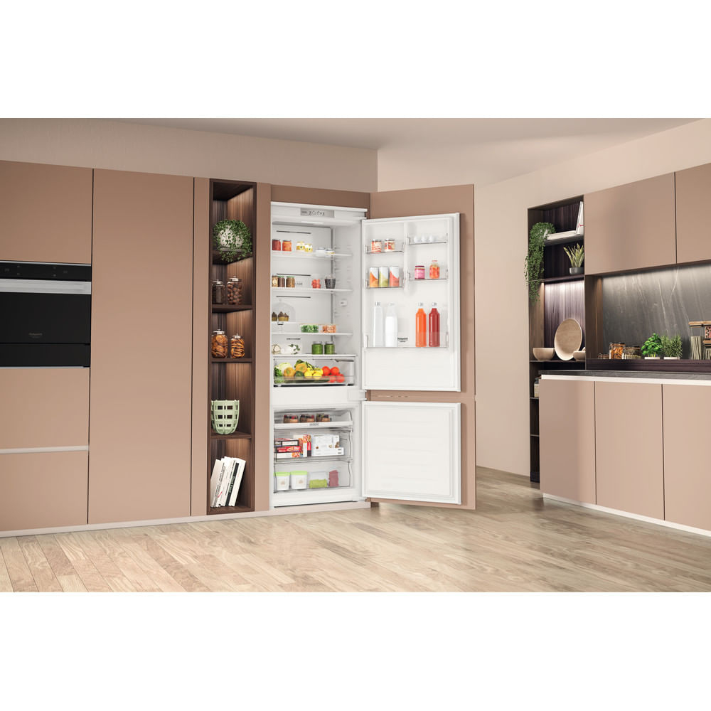 Frigorifero aperto in una cucina moderna con mobili color cuoio e pavimenti in legno.
