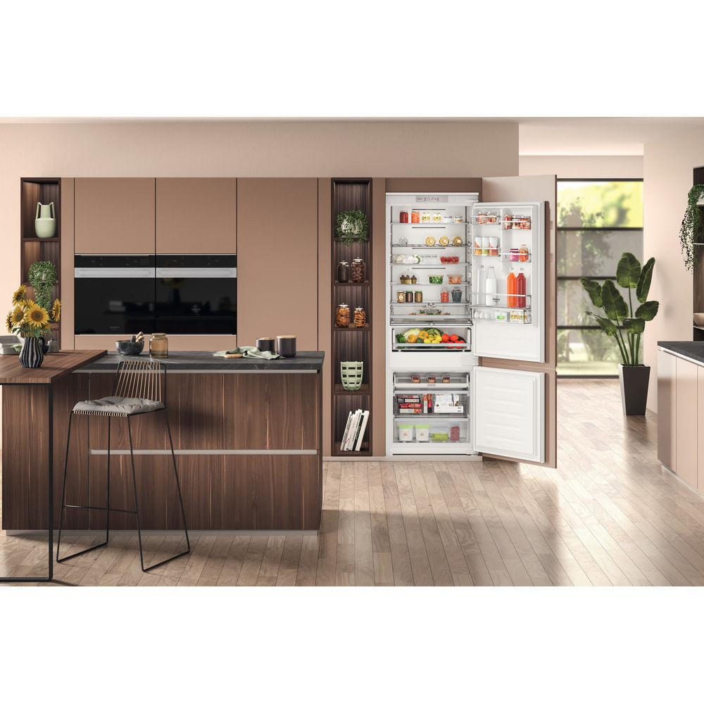 Cucina moderna con frigorifero aperto, zona pranzo ed elettrodomestici.