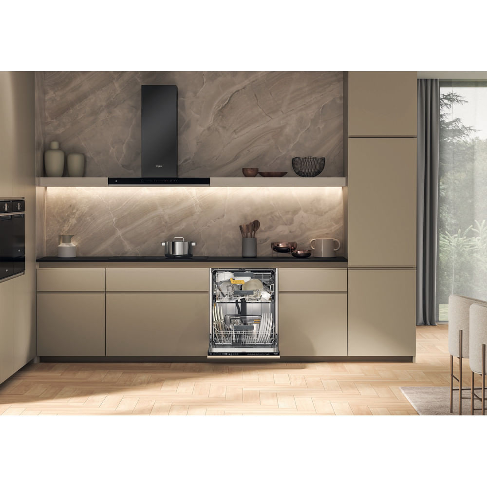Cucina moderna con lavastoviglie aperta, cappa nera e paraschizzi in marmo.