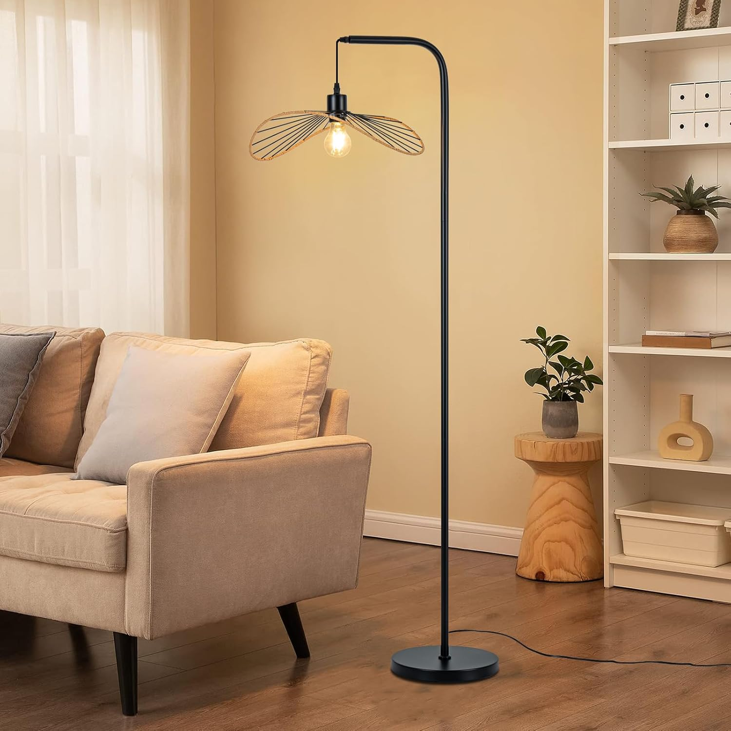 Nowoczesna lampa podłogowa z kloszem w kształcie skrzydła nad beżową sofą.