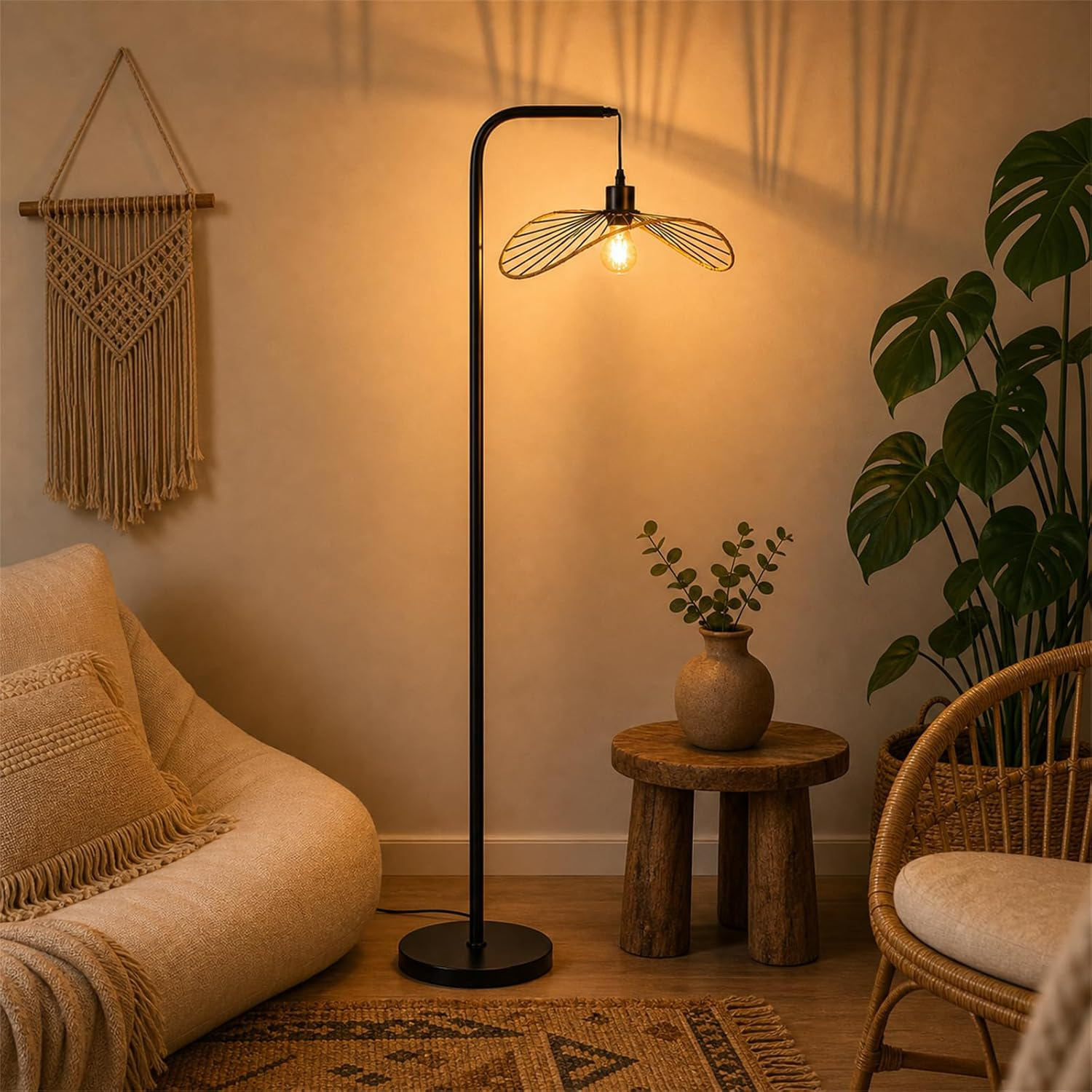 Beżowy fotel, lampa podłogowa z kloszem w kształcie liścia i roślina.