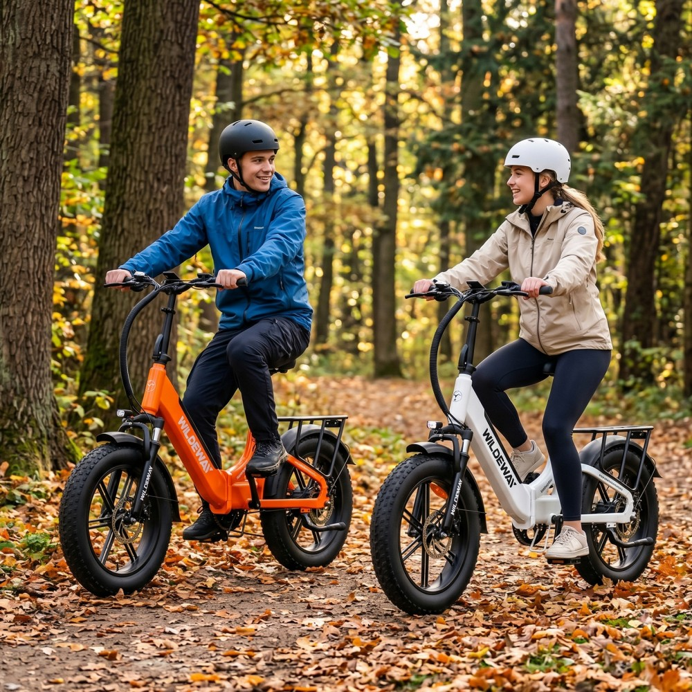 Dwóch rowerzystów na rowerach elektrycznych w jesiennym lesie z kolorowymi liśćmi.