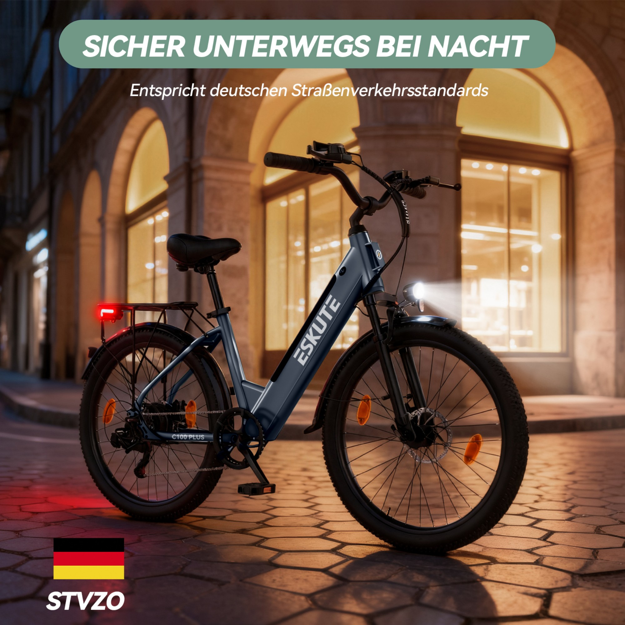 Ciemny rower elektryczny zaparkowany nocą na brukowanej ulicy przed oświetlonym budynkiem.