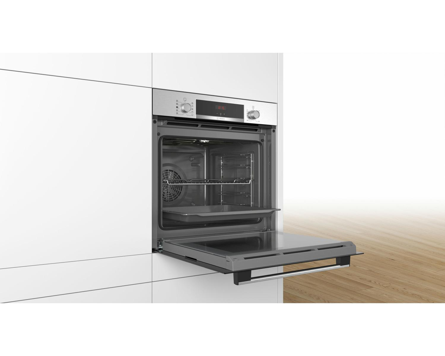 Un moderno forno argentato con porta aperta e griglia, su pavimento in legno.