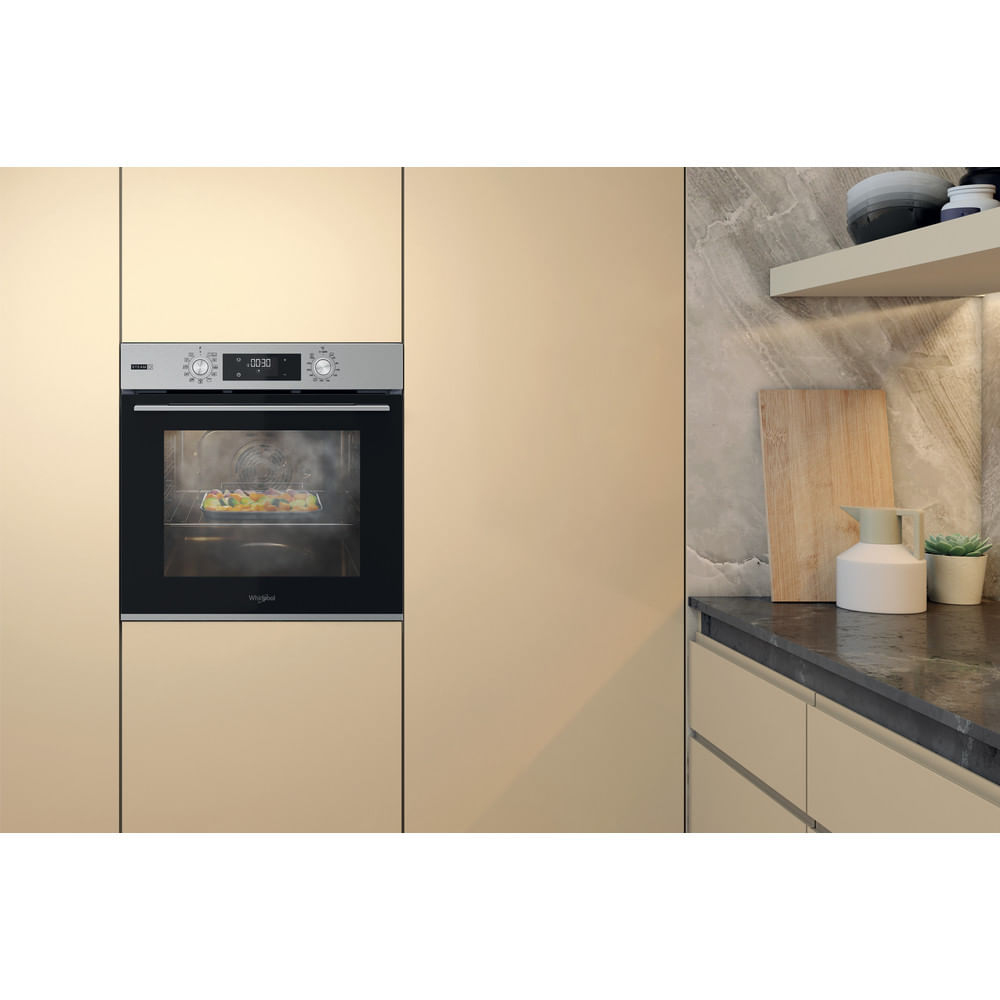 Un forno da incasso moderno con display digitale, che mostra cibo in cottura all'interno.