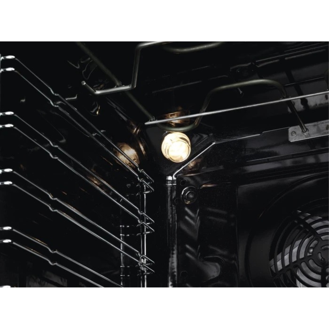 Interno di un forno con luce accesa, griglie e ventola.