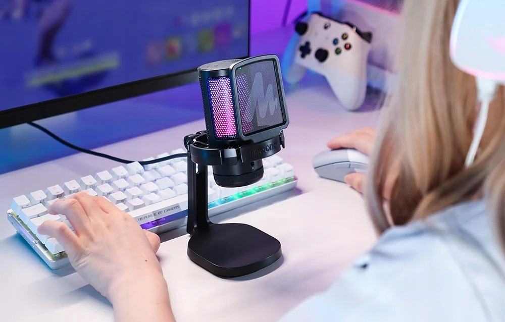 Ein Gamer benutzt eine weiße Tastatur, eine Maus und ein Mikrofon mit RGB-Licht.