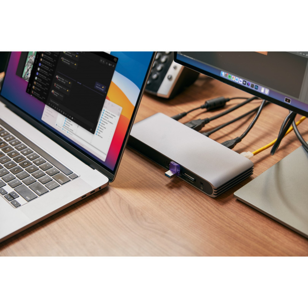 Un laptop, una docking station e un monitor su una scrivania di legno.