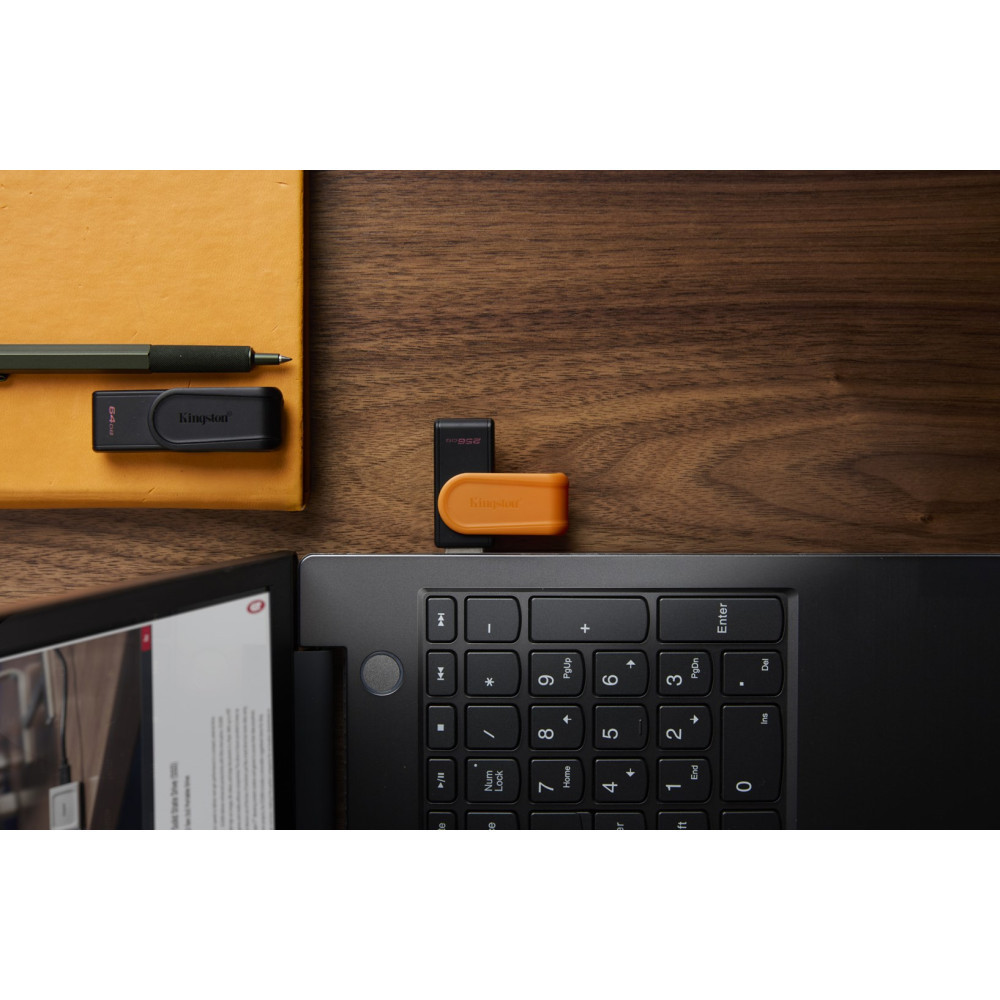 Two Kingston USB drives rest on a keyboard. A notebook and pen are nearby.
