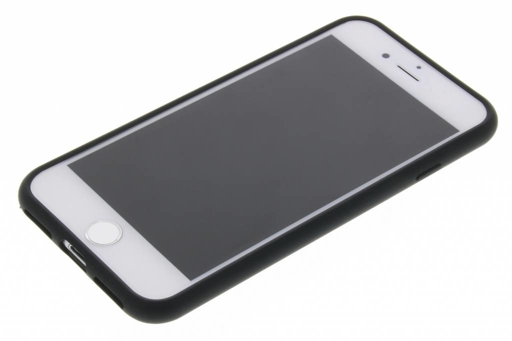 Uno smartphone nero con schermo vuoto giace su una superficie bianca.