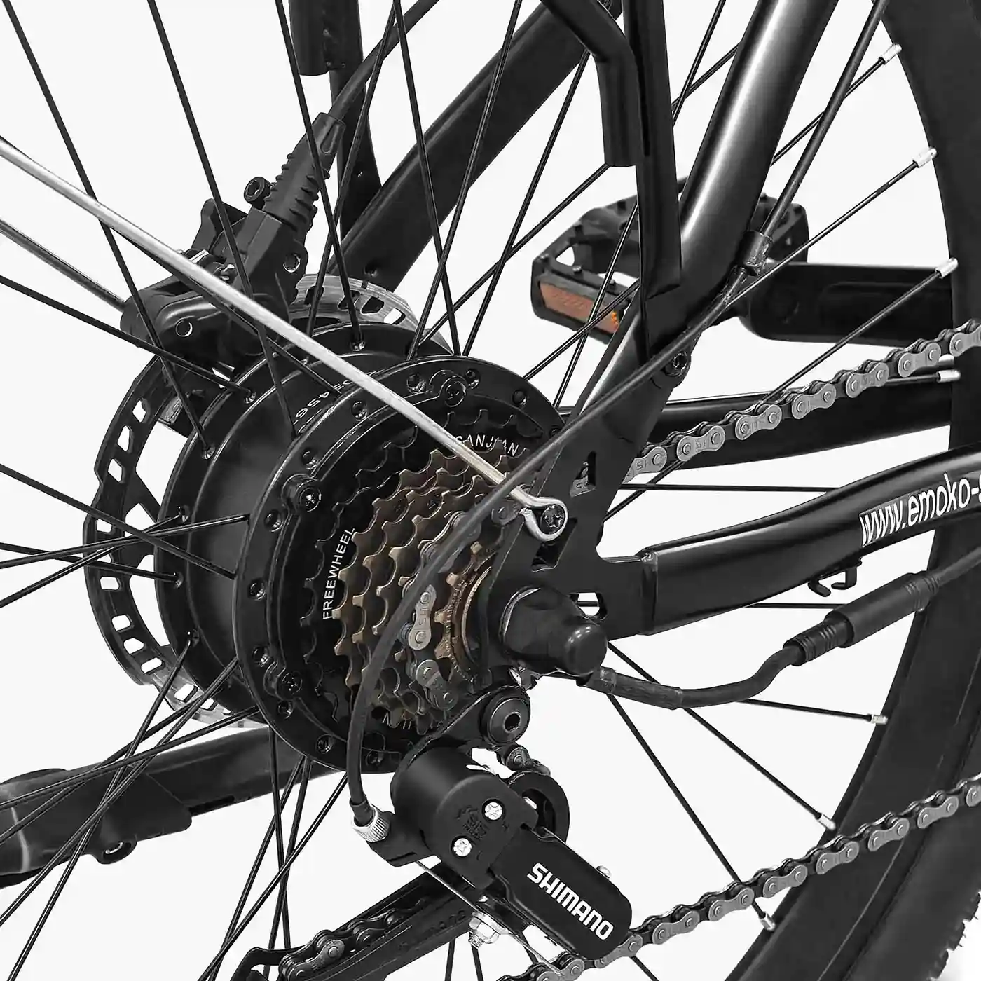 Primer plano de la rueda trasera de una bicicleta negra, con cadena, engranajes y freno de disco.