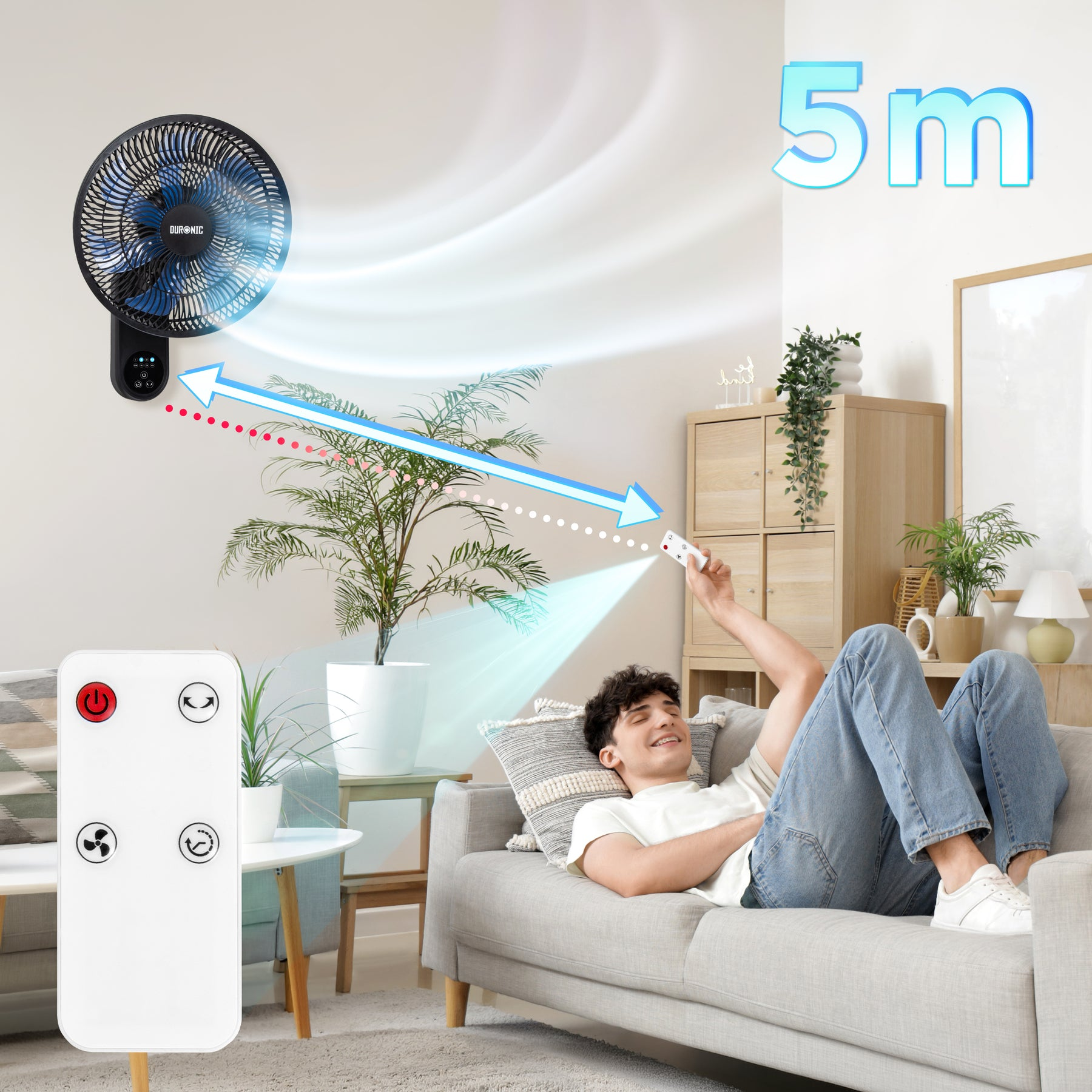 Ein Mann liegt auf einer Couch und hält eine Fernbedienung. Ein Ventilator bläst Luft.